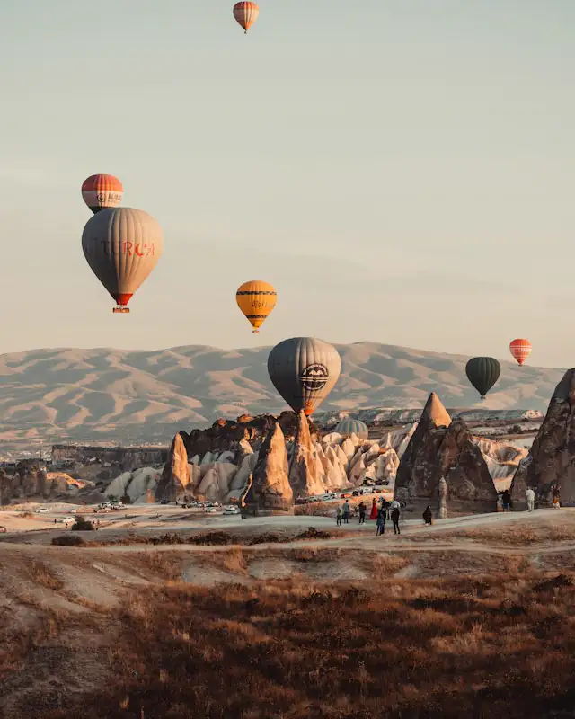 Kapadokya'da peribacalarının üzerinde gün doğumunda balonlar