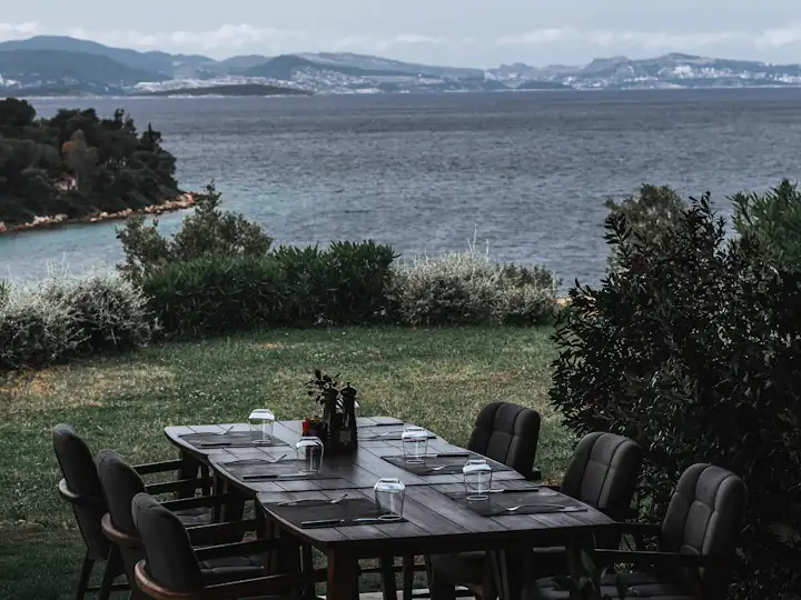 Ege koyuna bakan bahçede kurulmuş uzun akşam yemeği masası